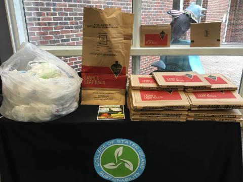 Bagdrive Bag drive table with paper leaf bags and donated plastic bags on top of the table.